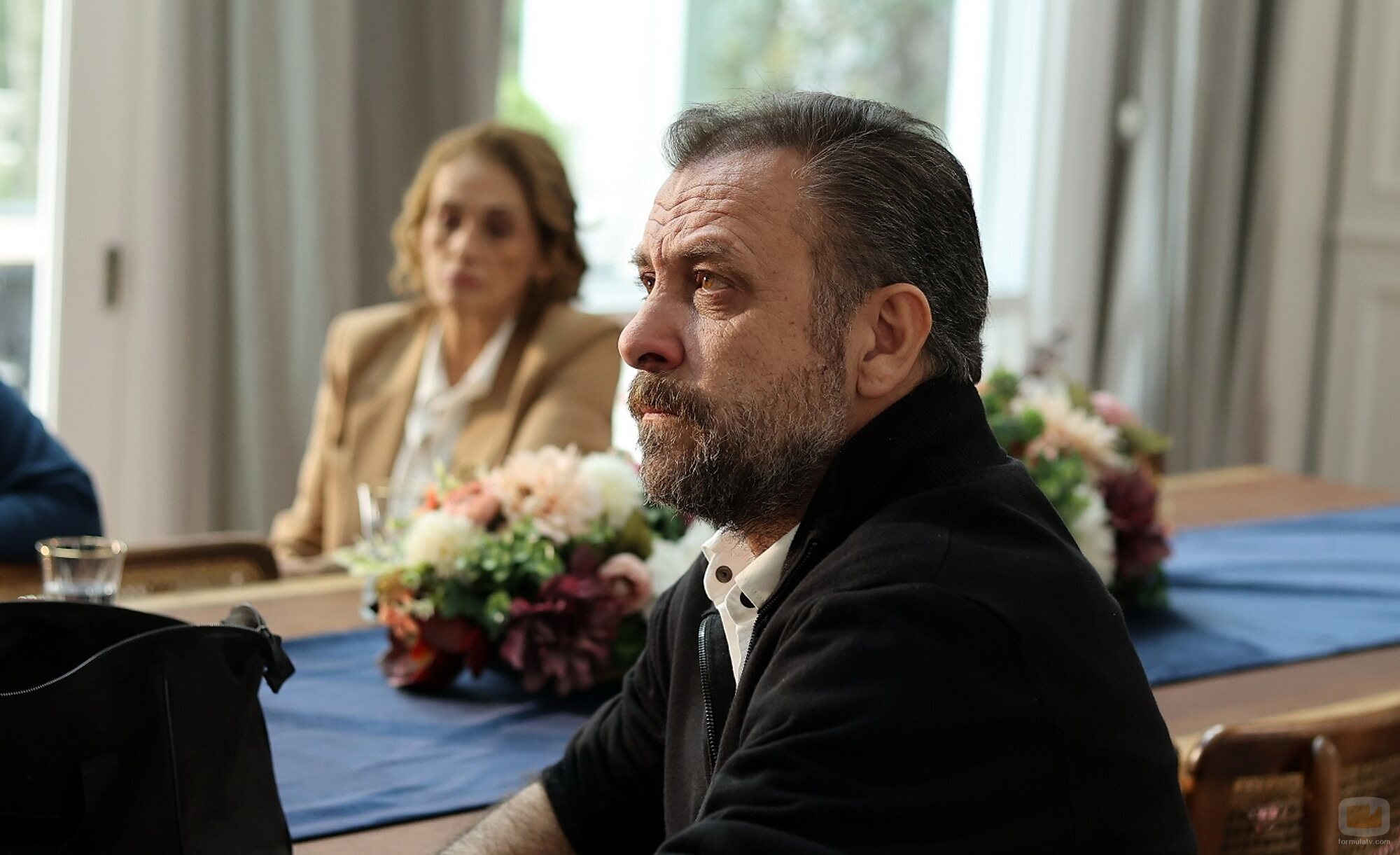 Un hombre con barba, sentado a la mesa en 'Familia'