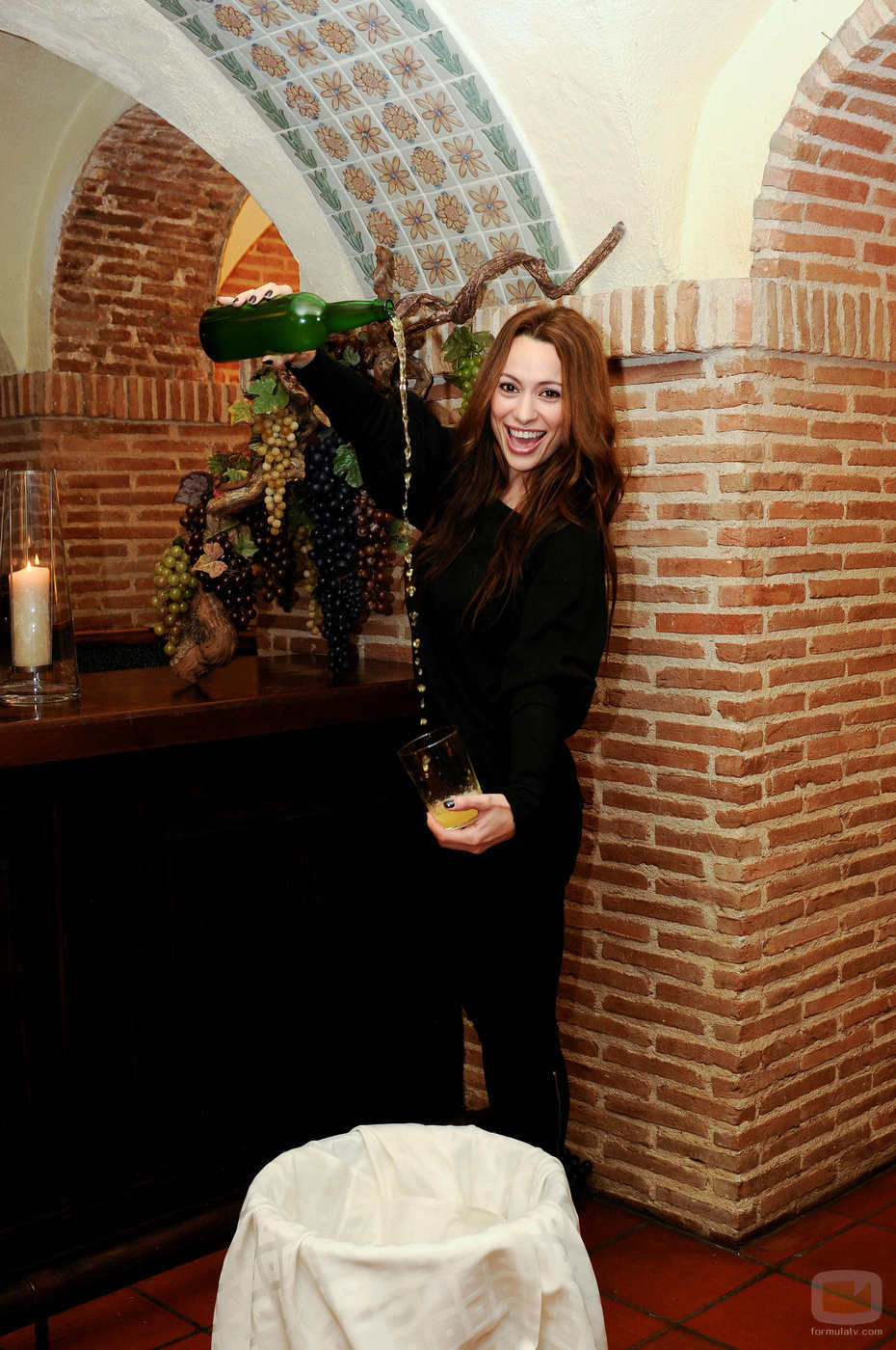Natalia Verbeke escanciando sidra en un restaurante