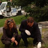 Melina Kanakaredes y Gary Sinise junto a un cadáver enterrado
