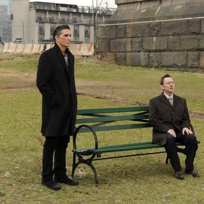 Finch habla con Reese desde un banco en 'Person of Interest'