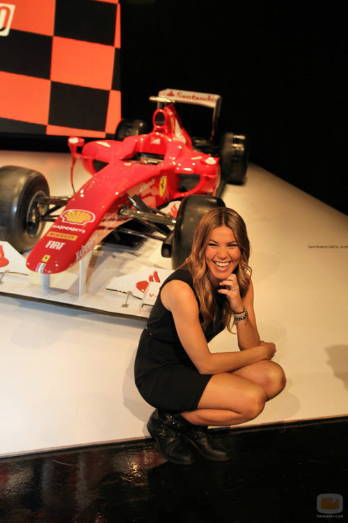Nira Juanco sonríe frente a un Ferrari