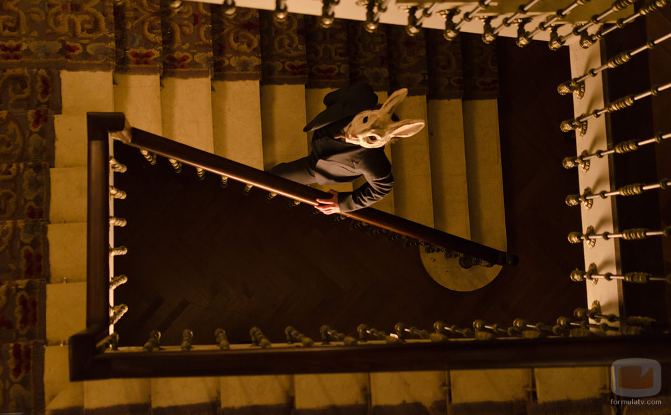 Un hombre disfrazado con una máscara de conejo subiendo las escaleras del Gran Hotel