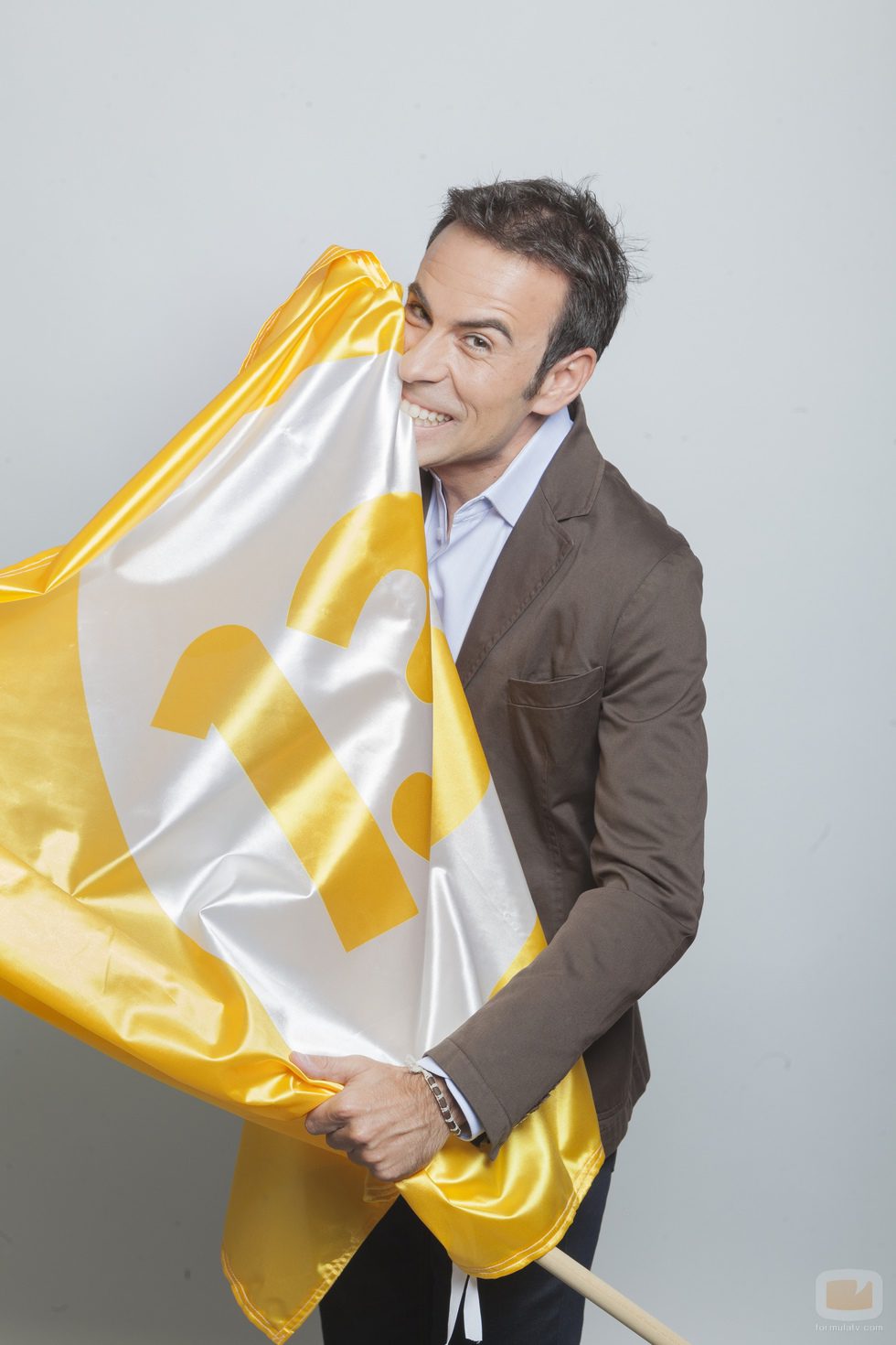 Felipe del Campo junto a la bandera del canal 13tv