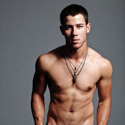 Nick Jonas sin camiseta marcando abdominales