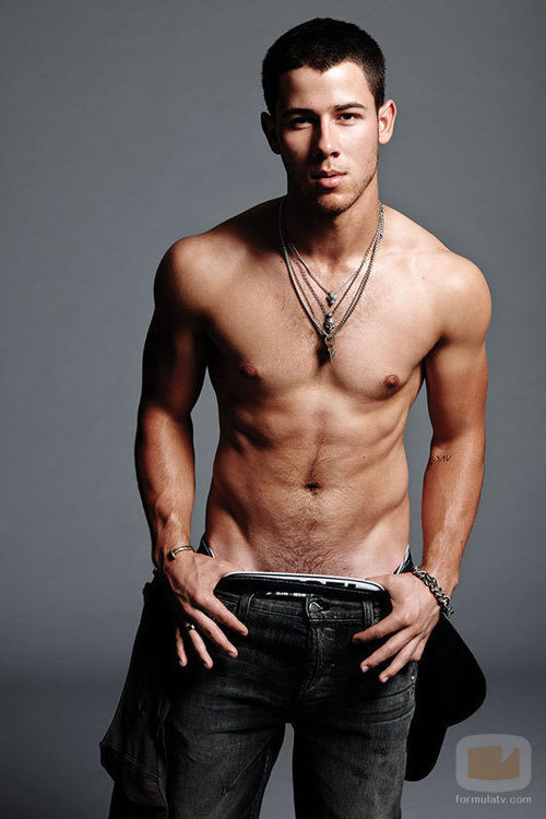 Nick Jonas sin camiseta marcando abdominales