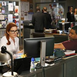 Debra Messing y Laz Alonso en la oficina en 'The Mysteries of Laura'