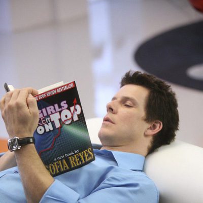 El actor Eric Mabius lee tumbado en 'Ugly Betty'
