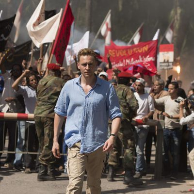 Tom Hiddleston camina delante de la multitud en 'El infiltrado'