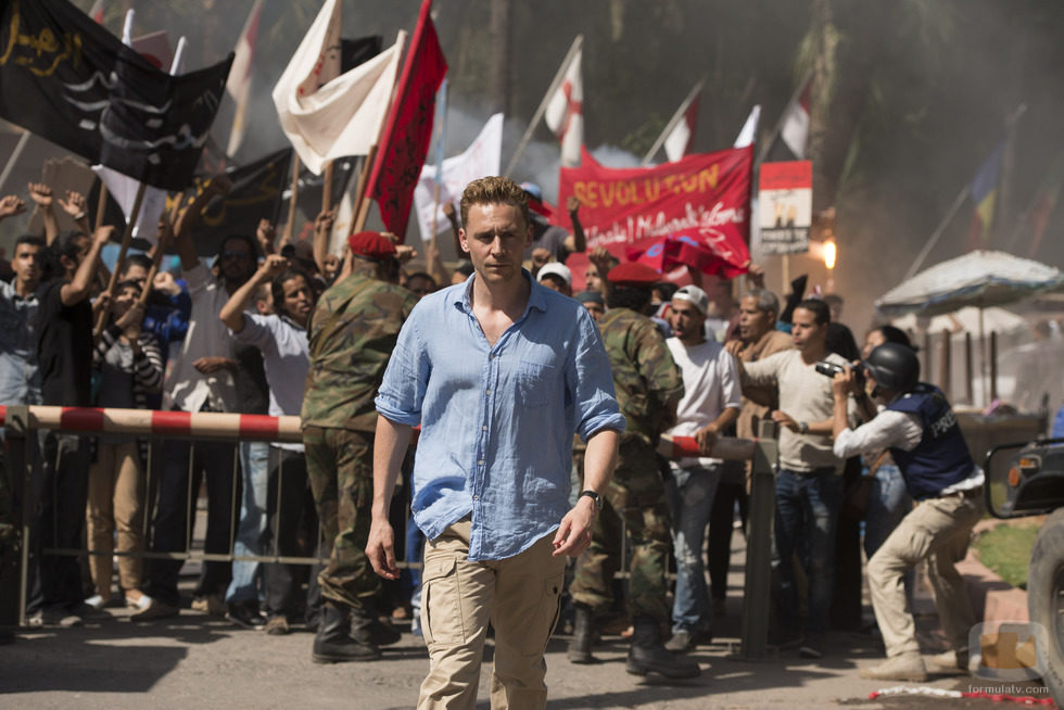 Tom Hiddleston camina delante de la multitud en 'El infiltrado'