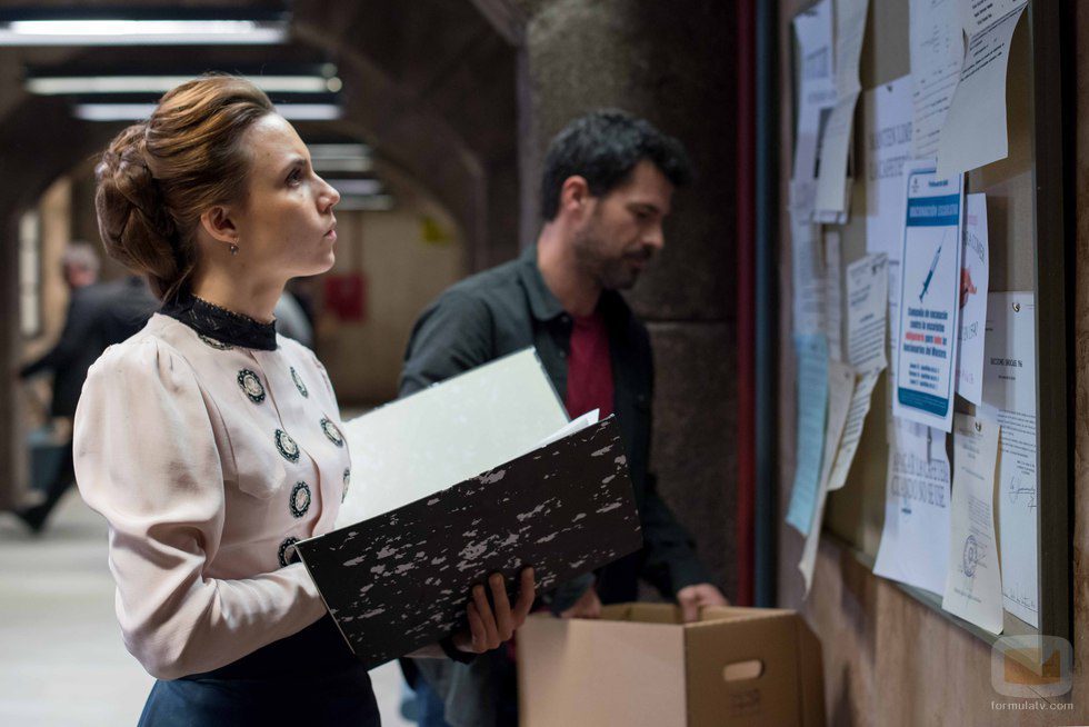 Amelia observa un tablón de anuncios junto a Julián