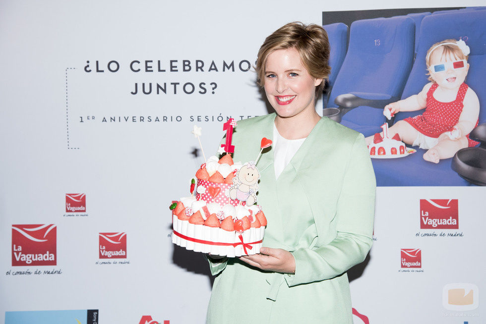 Tania Llasera sostiene sonriente una tarta de golosinas