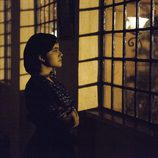 Una preocupada Tata Escobar mira por la ventana en 'Narcos'