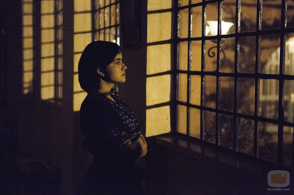 Una preocupada Tata Escobar mira por la ventana en 'Narcos'