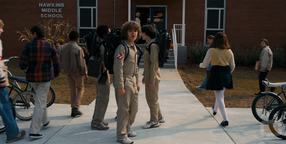 Dustin con los demás chicos, a las puertas del Instituto de Hawkins, vestido como los Cazafantasmas en la segunda temporada de 'Stranger Things'