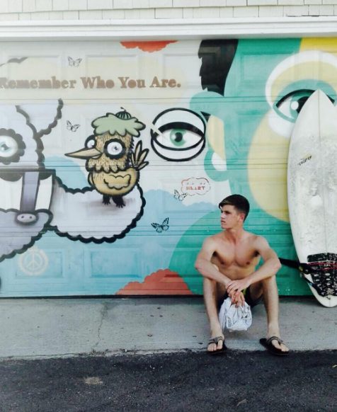 Miguel Bernardeau, sentado junto a su tabla de surf