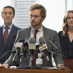 Daniel Rand (Finn Jones), Ward Meachum (Tom Pelphrey) y Joy Menchum (Jessica Stroup) durante una rueda de prensa en 'Iron Fist'