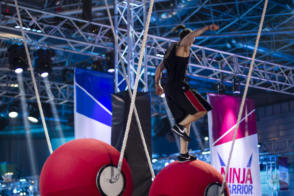 Un concursante en el puente giratorio de 'Ninja Warrior'