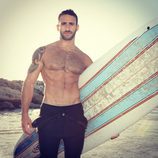 Eliad Cohen en la playa con una tabla de surf