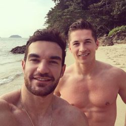 James Longman posa sin camiseta junto a un amigo en la playa