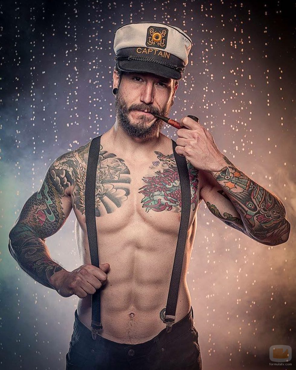 Daniel G. Prim, semidesnudo, con tirantes y una gorra de marinero