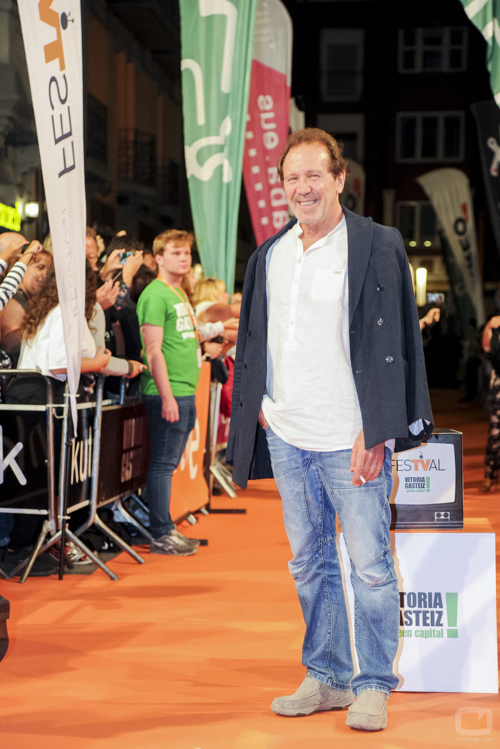 Pose de Juan Gea, actor del 'Ministerio del Tiempo', sonriendo en la alfombra naranja del FesTVal