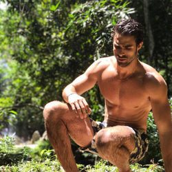 Juan Betancourt, desnudo en bañador, sobre un verde paisaje
