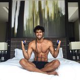 Juan Betancourt sonríe semidesnudo en la cama