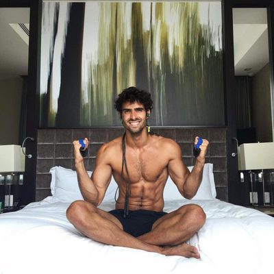 Juan Betancourt sonríe semidesnudo en la cama