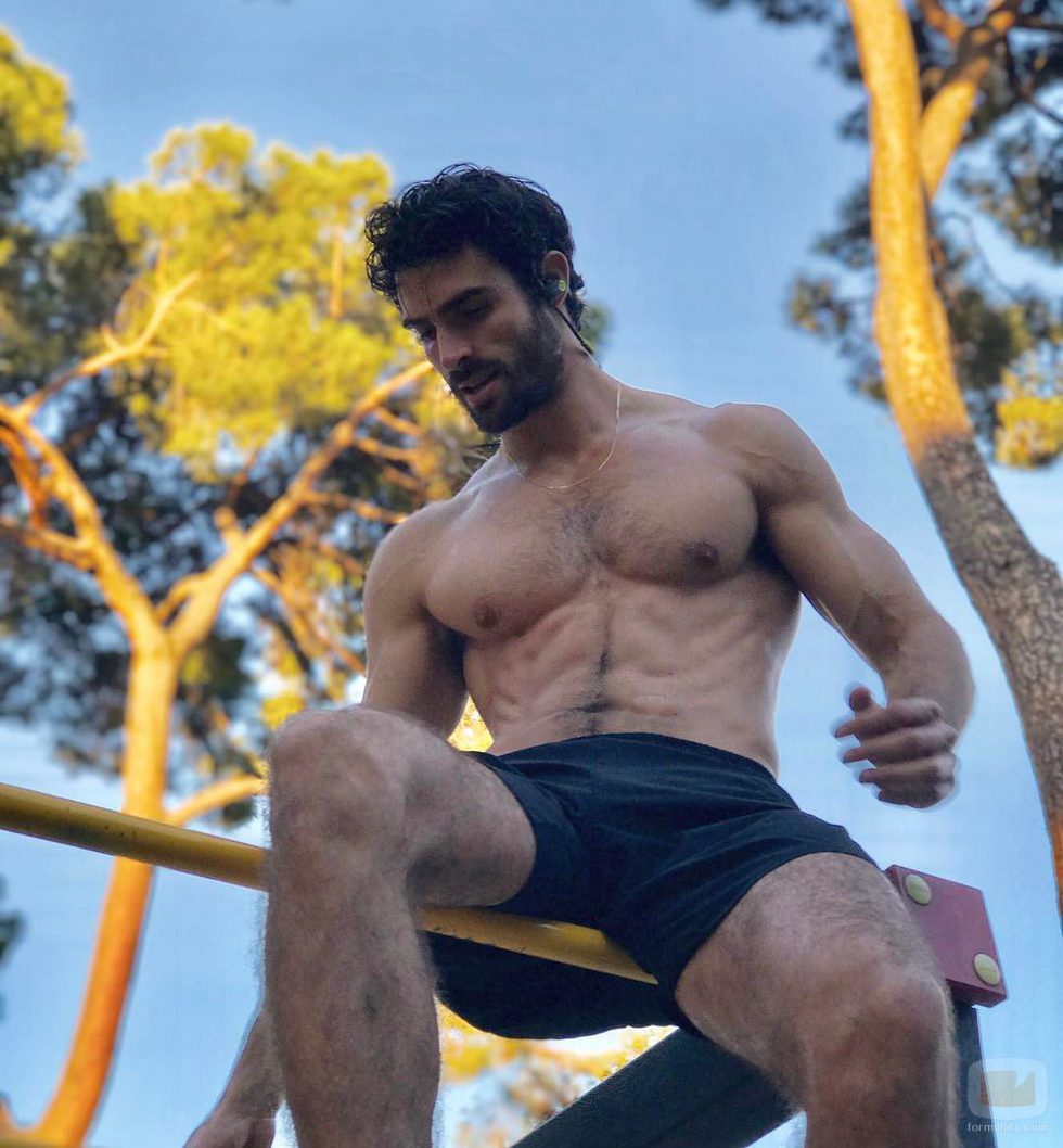 Juan Betancourt, desnudo, se sienta sobre una barra de metal