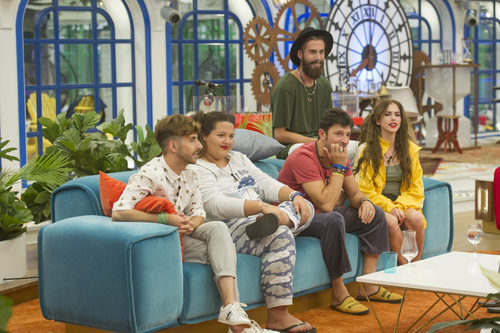 Algunos concursantes de 'GH Revolution' esperan sentados en el salón durante la cuarta gala