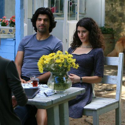 Kerim y Fatmagül hablando con una mujer en una terraza en uno de los últimos episodios de 'Fatmagül'