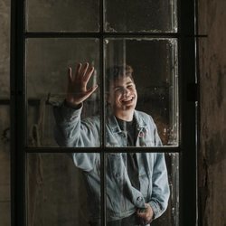 Alfred García posa tras un cristal con una chaqueta vaquera 