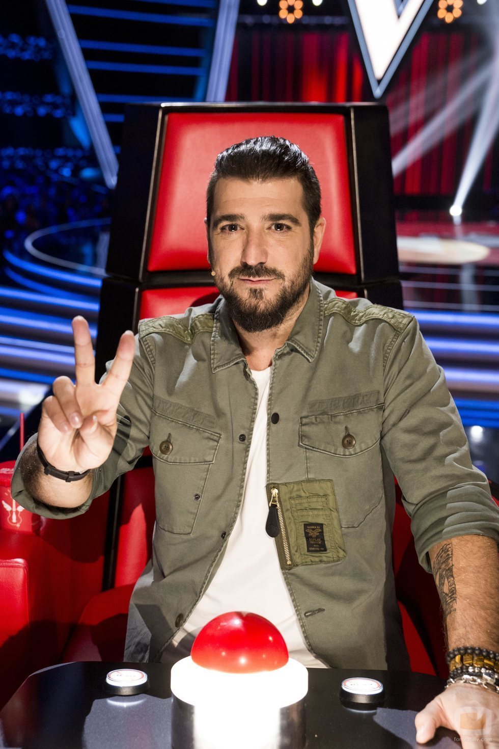 Antonio Orozco posa haciendo el gesto de 'La Voz' en su sillón de coach