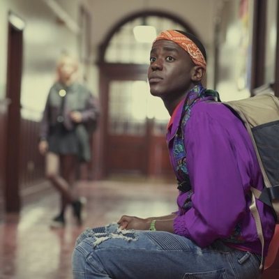Ncuti Gatwa sentado en el pasillo en 'Sex Education'