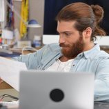 Can Yaman lee atento unos papeles en 'Pájaro Soñador'