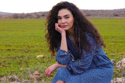 Reyyan (Ebru Sahin) sentada y posando en 'Hercai'
