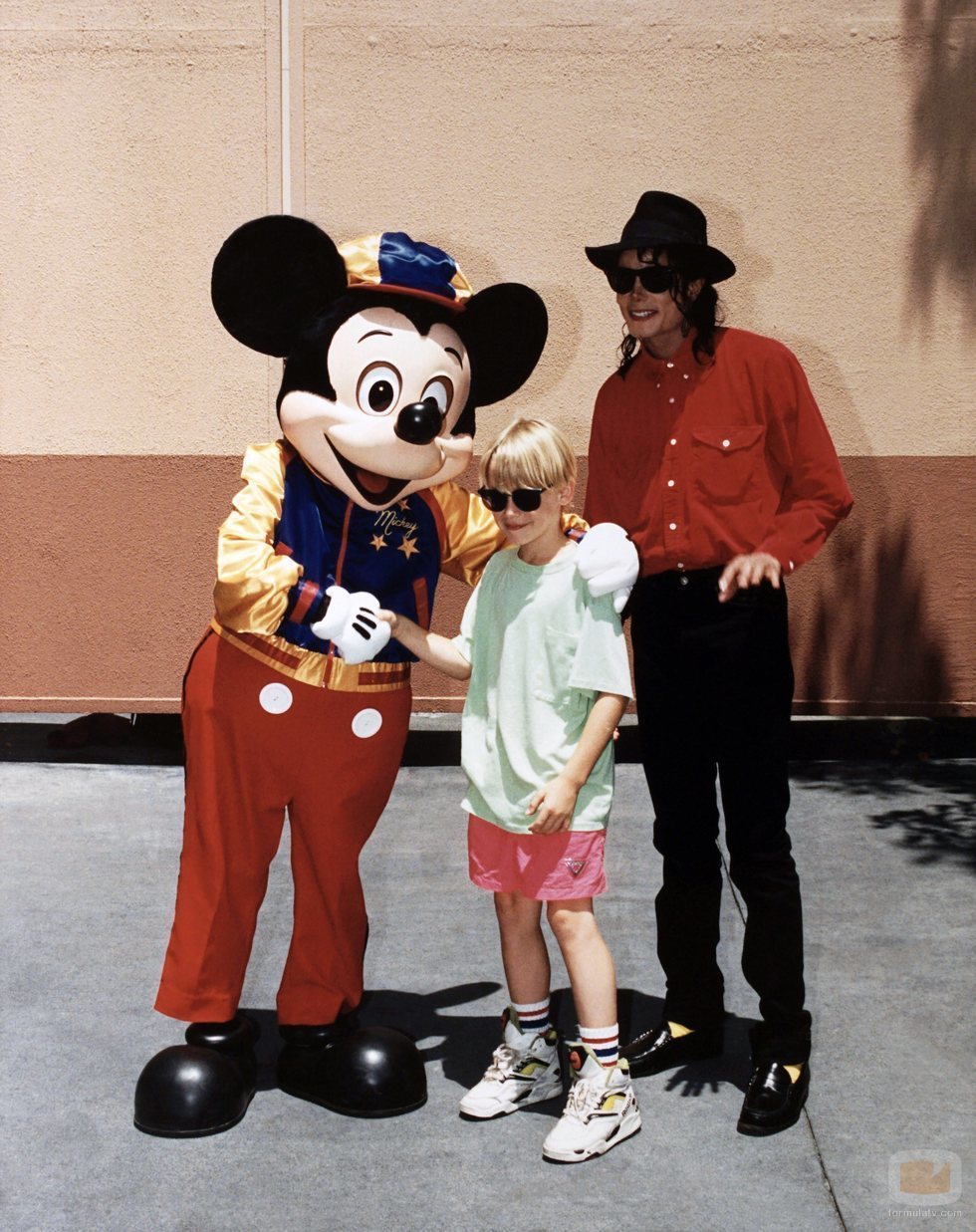 Michael Jackson y Macaulay Culkin posan con Mickey Mouse en Disneyland