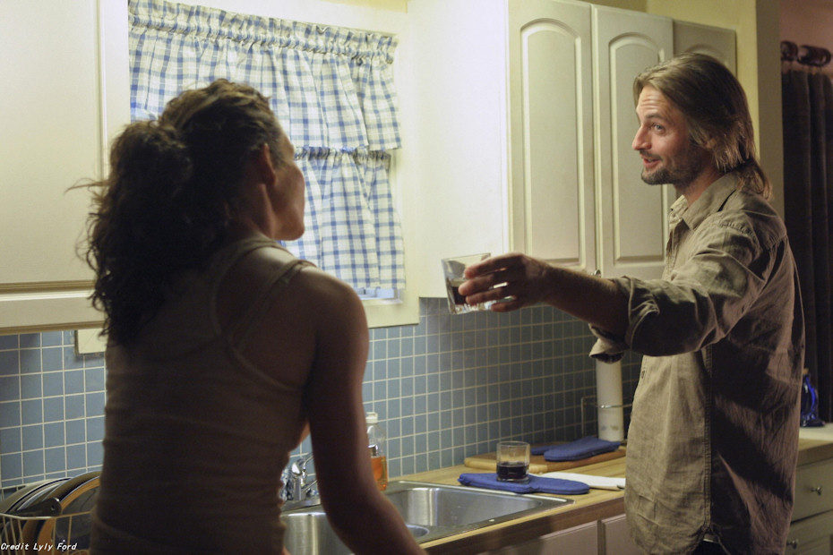 Sawyer ofrece un vaso de agua a Kate en 'Perdidos'