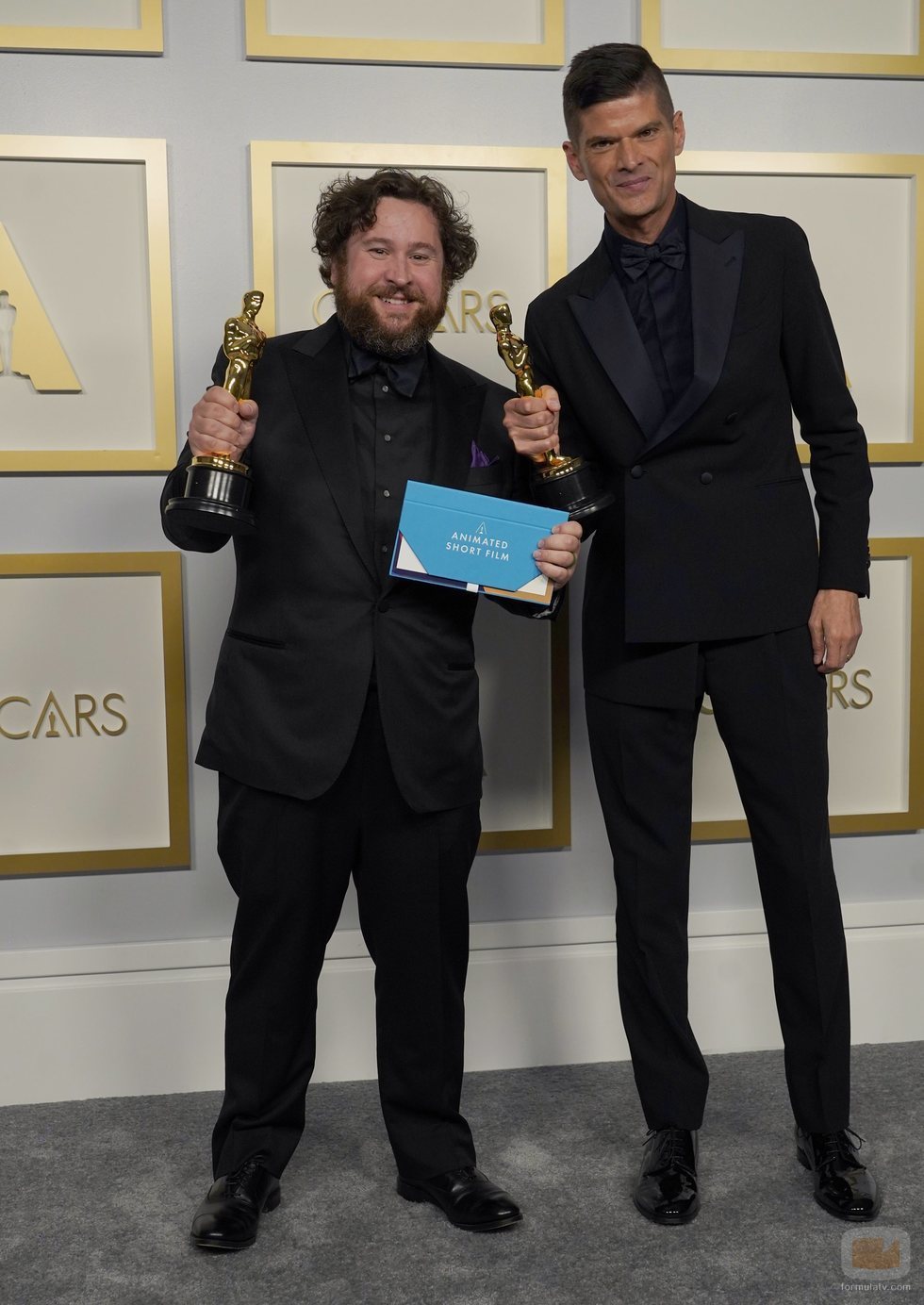 Michael Govier y Will McCormack posan con la estatuilla a Mejor Corto de Animación
