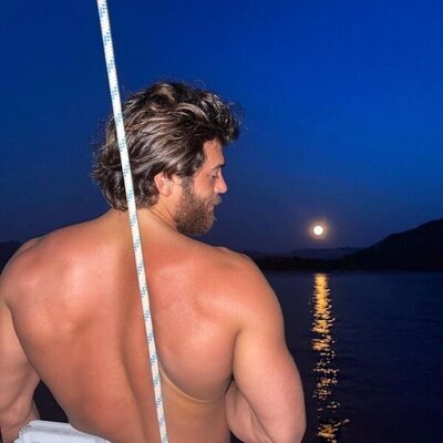 Can Yaman posa de espalda en un barco