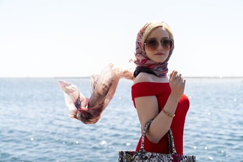 Julia Garner posando frente al mar en 'Inventing Anna'