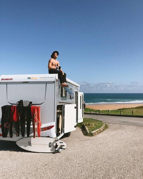 André Lamoglia, sin camiseta, sobre una caravana