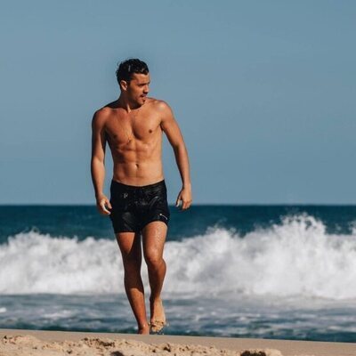 André Lamoglia, en bañador, en la orilla de la playa