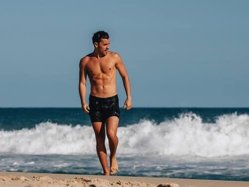 André Lamoglia, en bañador, en la orilla de la playa