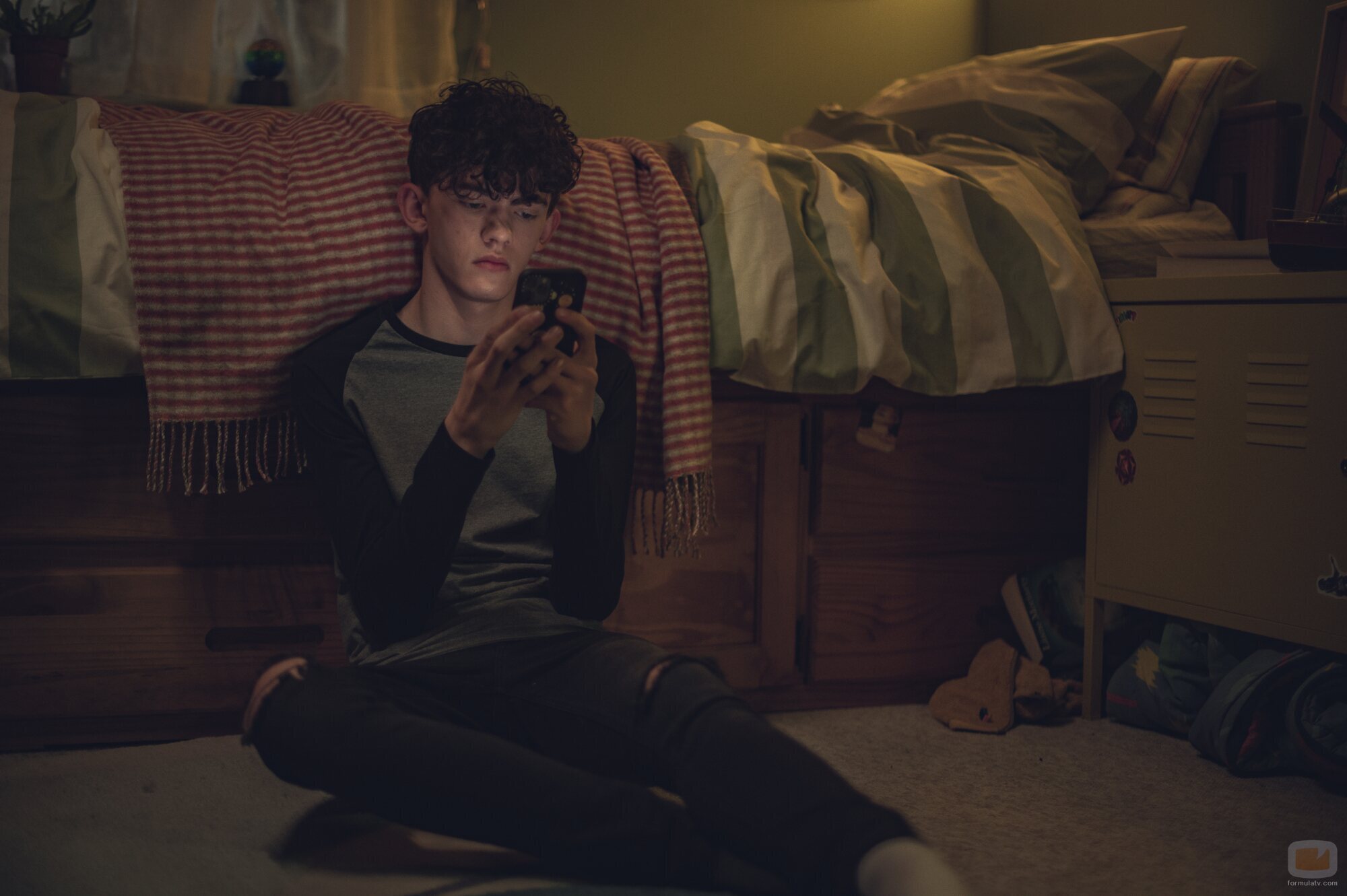 Charlie Spring mira el móvil en 'Heartstopper'