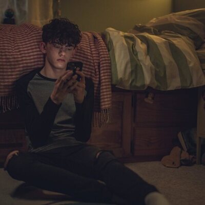 Charlie Spring mira el móvil en 'Heartstopper'