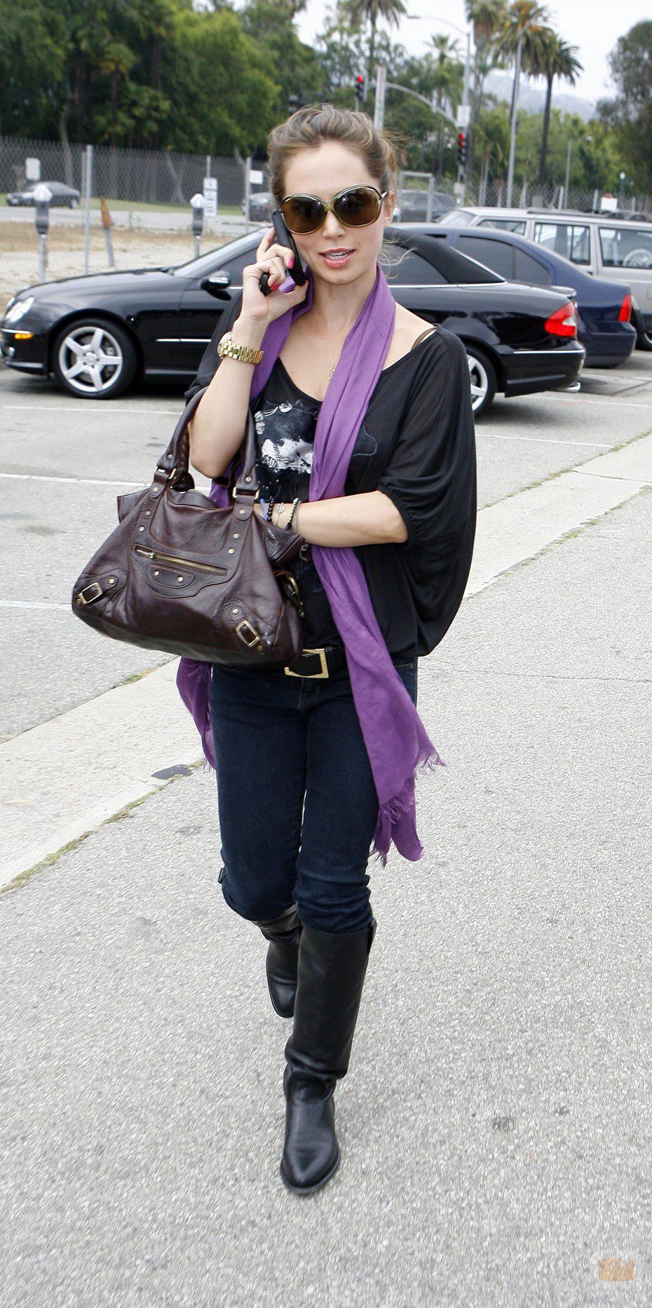 Eliza Dushku busca algo en el bolso mientras habla por teléfono