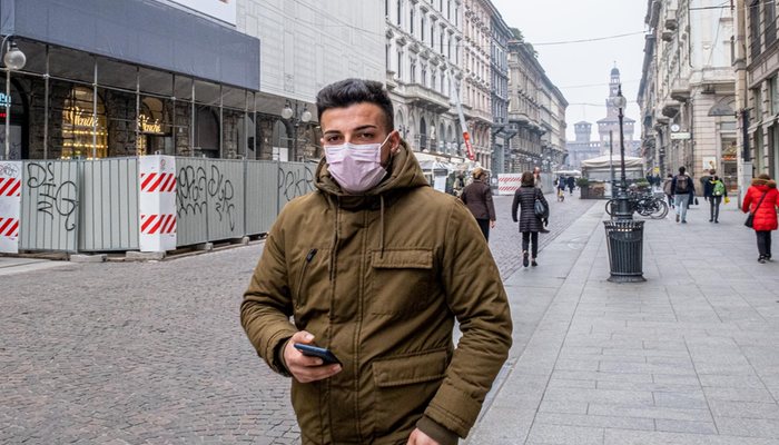 Un joven camina con mascarilla por Milán