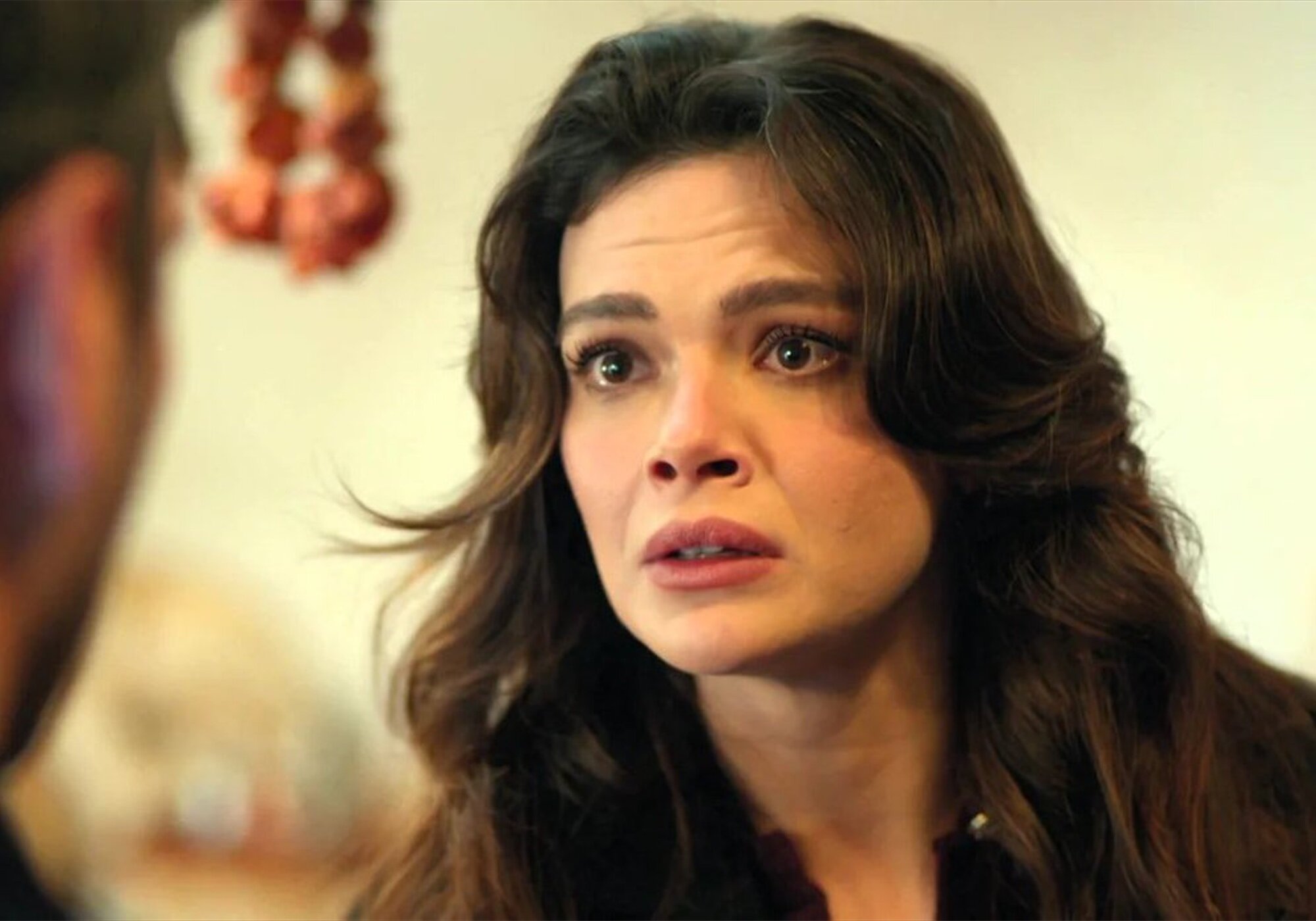 La protagonista de 'En tierra lejana' mira preocupada en esta escena de la serie