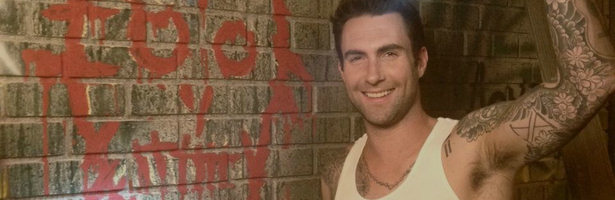 Adam Levine sonríe junto a un graffiti de Bloody Face.